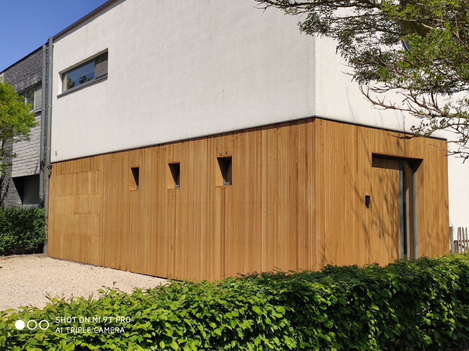 Moderne gevelrenovatie met houten afwerking op maat in Oost-Vlaanderen, getuigend van vakkundig renovatiewerk