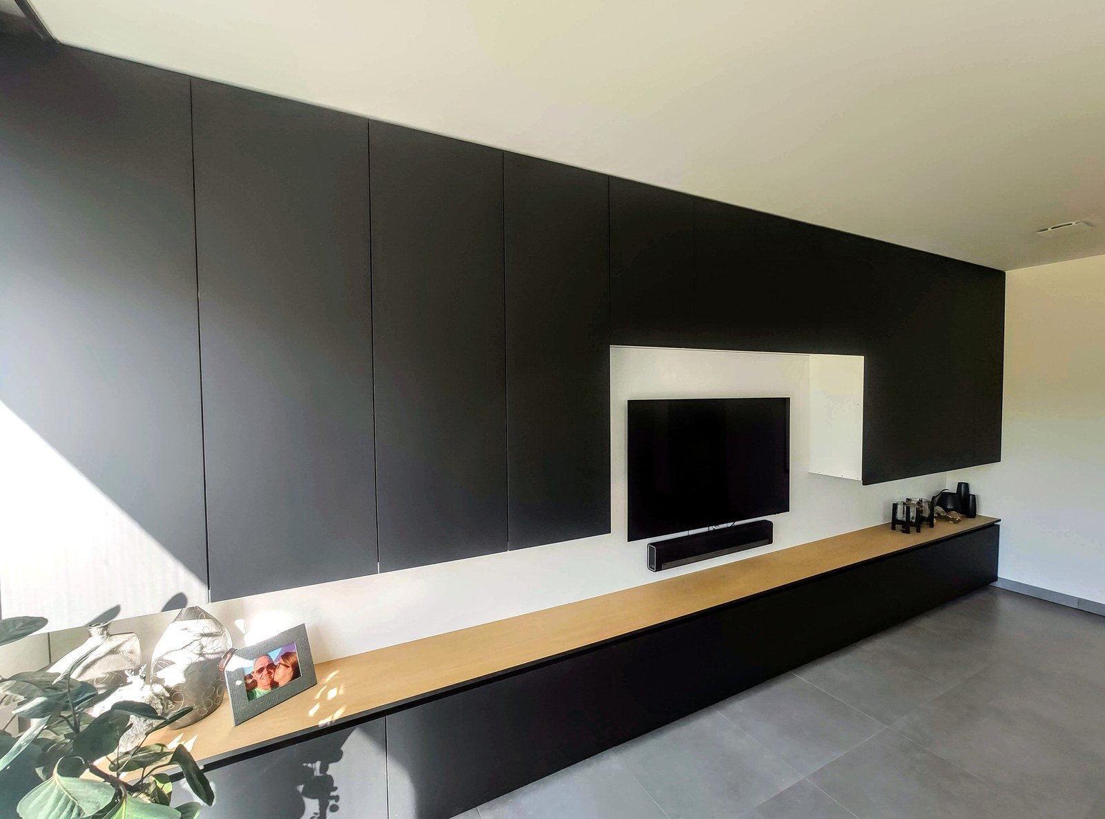 Moderne op maat gemaakte kasten met zwart schilderwerk en houten accenten. Professionele renovatie interieur in Oost-Vlaanderen.