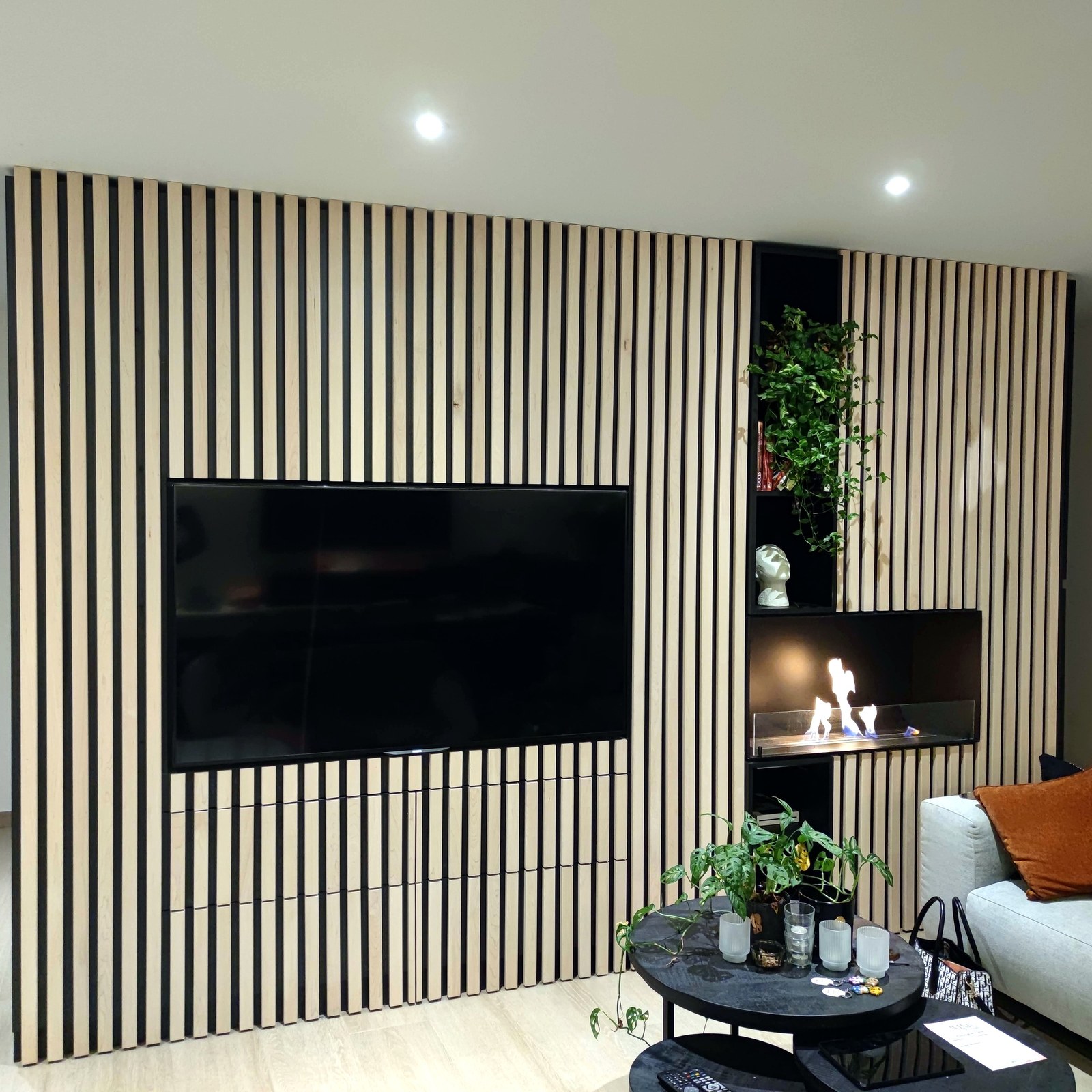 Modern interieur met op maat gemaakte houten wandbekleding en TV-niche, professionele renovatie uitgevoerd in Oost-Vlaanderen.