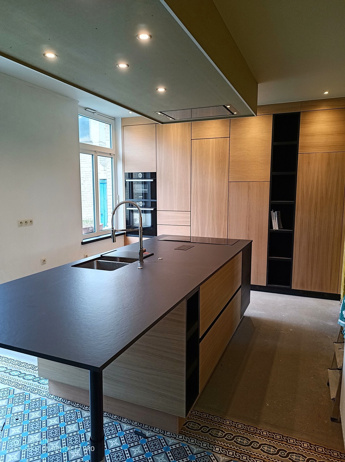 Moderne keuken op maat met zwart keukeneiland en houten kasten, professionele renovatie Oost-Vlaanderen door T Nieuw Project