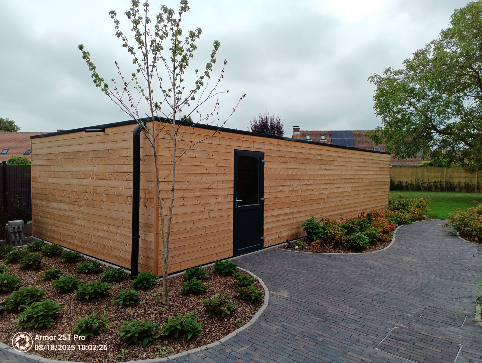 Moderne houten tuinhuisje op maat gebouwd door renovatiebedrijf T Nieuw Project in Oost-Vlaanderen met stijlvolle zwarte accenten